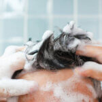 Photo d'un homme en train de se laver les cheveux